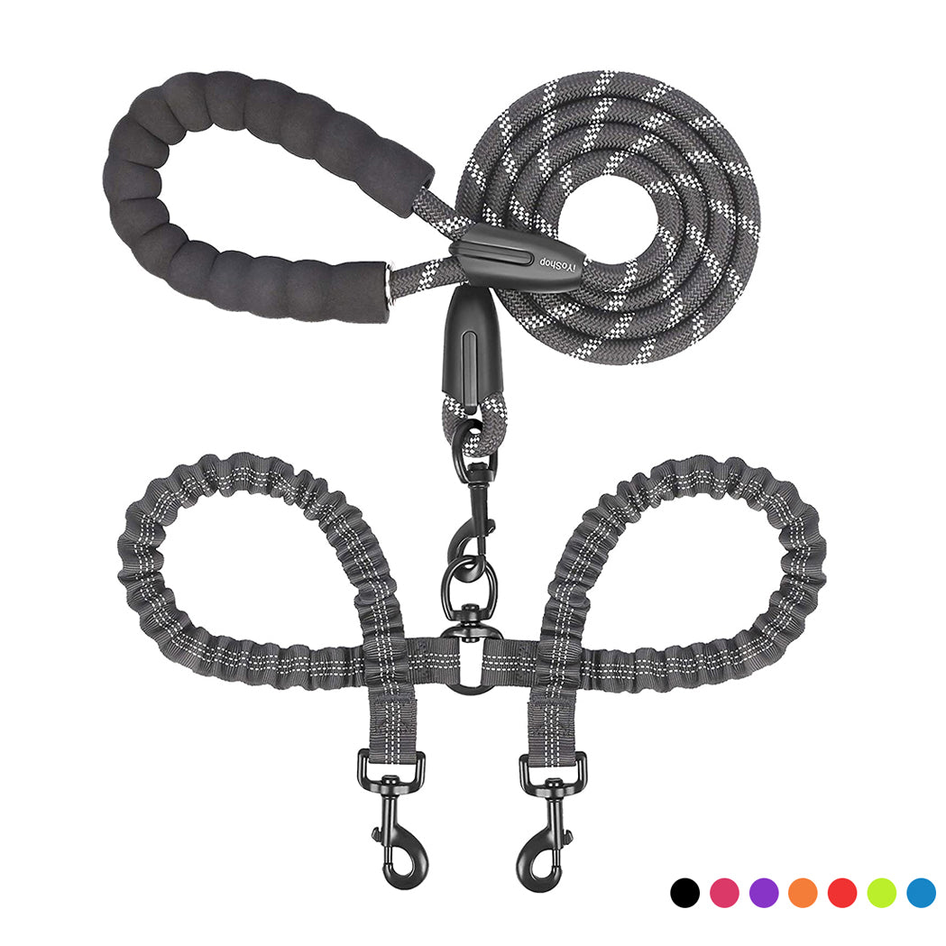 Double dog leash coupler by Zuka & Co. connecting two leashes for walking two dogs together in a park setting.