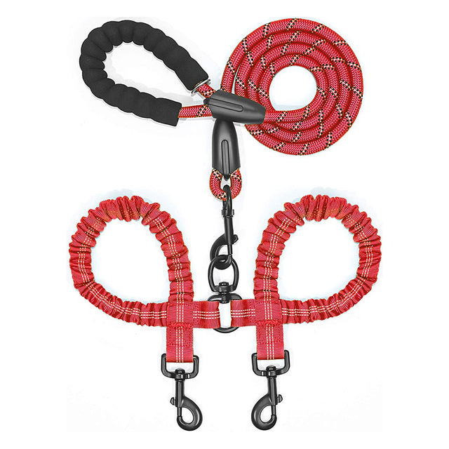 Double dog leash coupler by Zuka & Co. connecting two leashes for walking two dogs in a park setting.